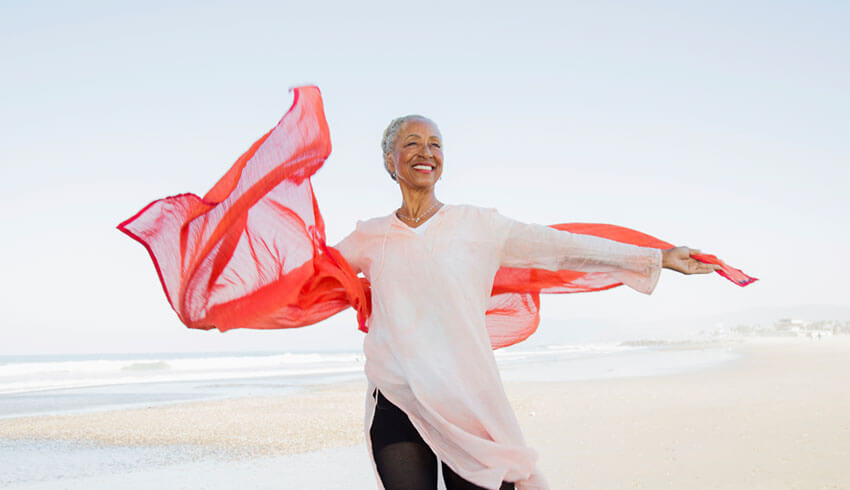 Mature woman with red scarf at the beach 