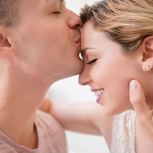 Man kissing woman's forehead